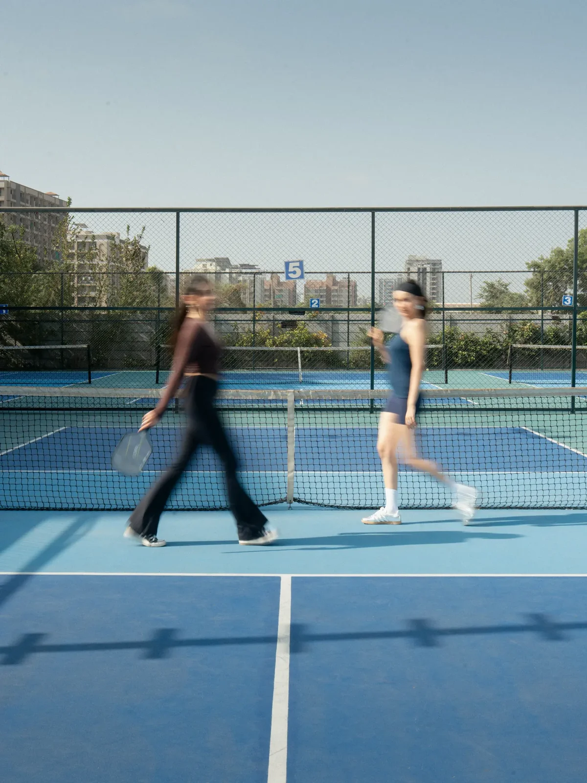 Ace Bounce players walking across the courts past the numbered court signs